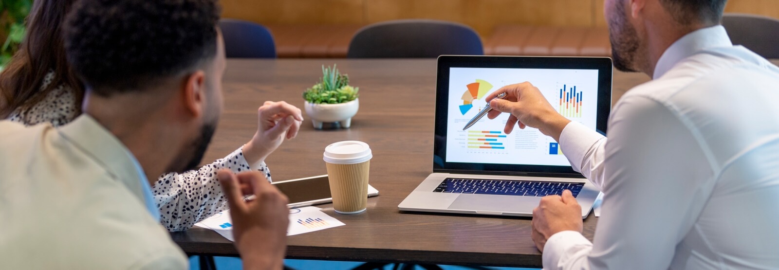 group of business people looking at graphs on a laptop