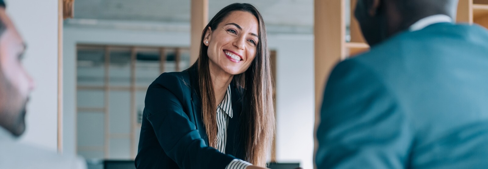 business woman shaking the hand of a man out of frame